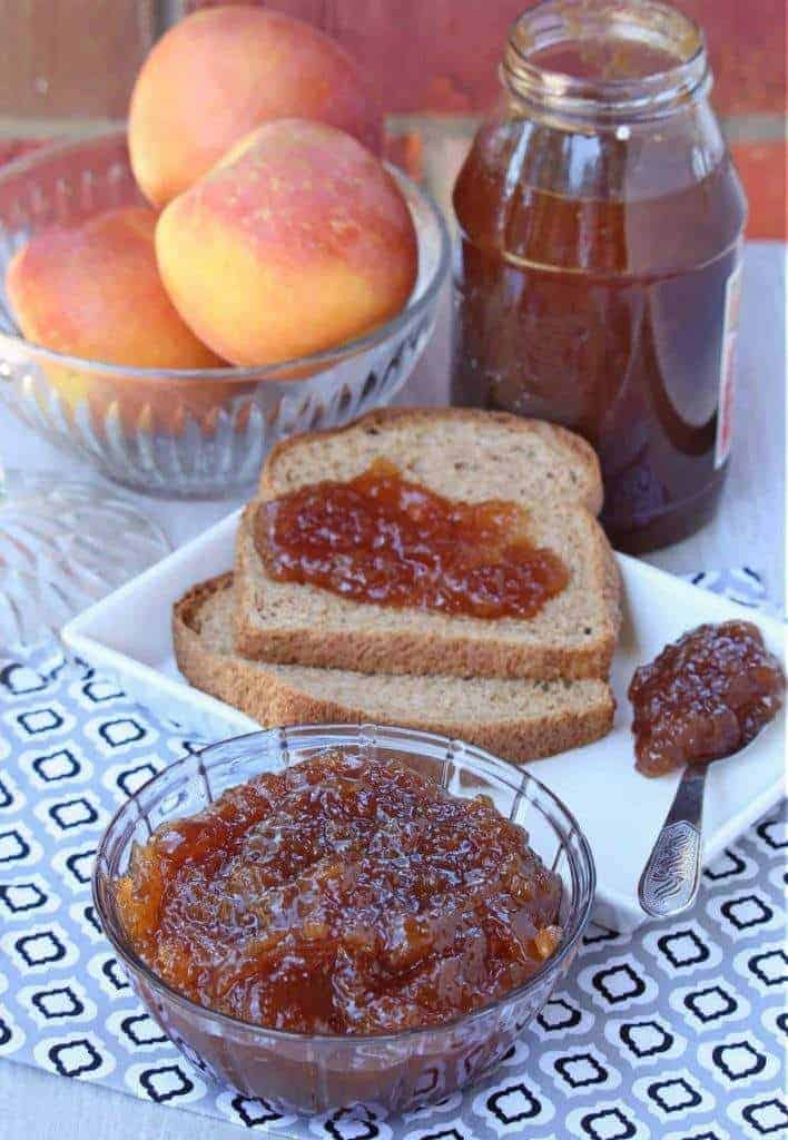 apple jam in a bowl with more on a bread and in a jar with apples in the background