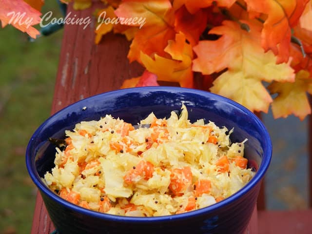Carrot Cabbage curry served in a blue bowl with some maple leaves