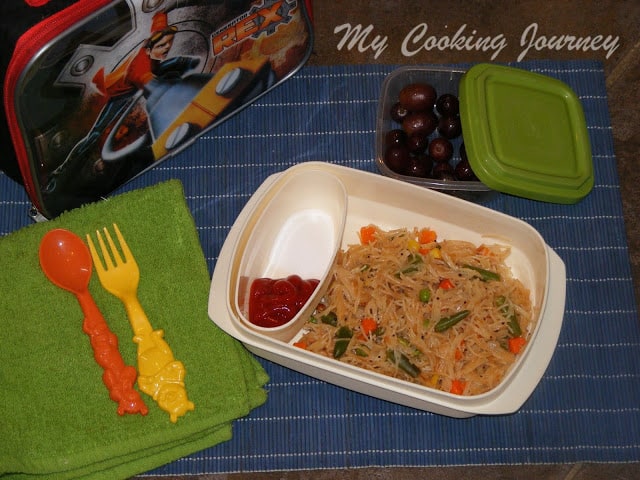 Semiya upma in a lunch box with grapes on side.