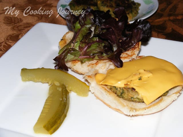 White bean and greens burger is ready and served with pickles and cheese