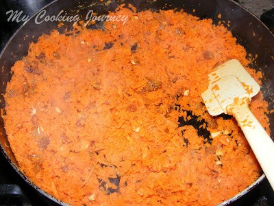 Mixing carrot with dry fruits.