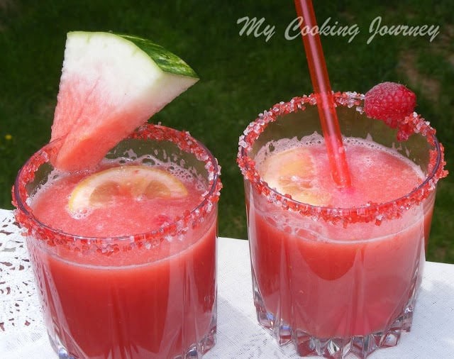 Watermelon Raspberry Lemonade in two glasses with a wedged water melon and straw