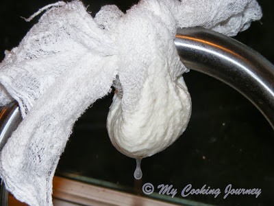 In a muslin cloth pouring the yogurt.