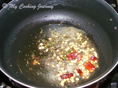 Frying mustard seeds, red chili and lentils in a pan