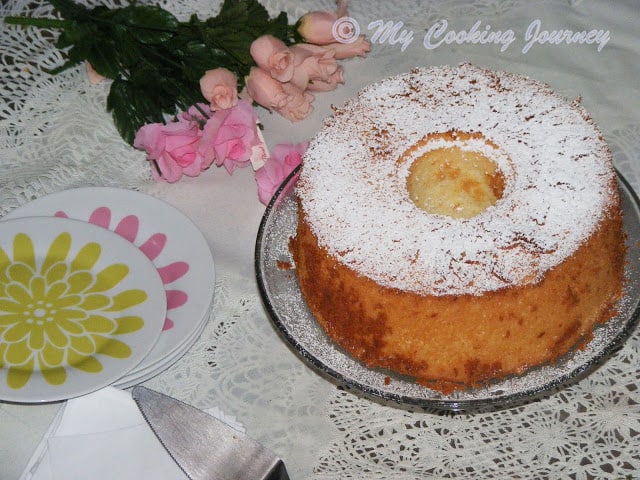 Lemon Glow chiffon cake decorated with flowers in background.