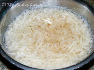 Shredded potatoes in a cold water in a bowl.