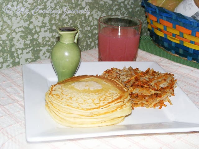 American breakfast Pancakes and Hashbrowns ready to serve with juice.