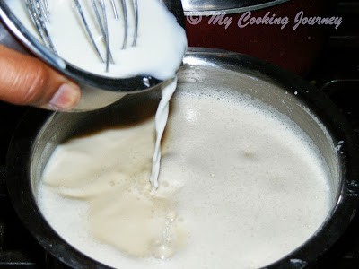 Adding corn flour mixture to boiling milk