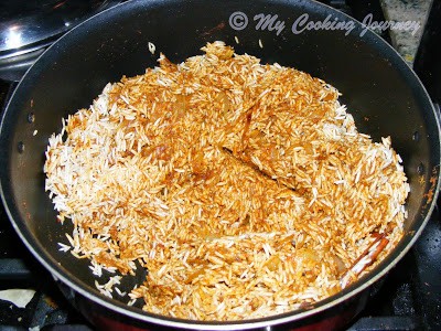 Adding the spices in the rice and cooking.