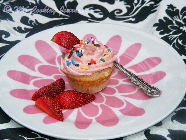 Strawberry Cupcakes with strawberry icing serve with strawberry.