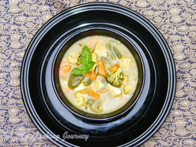 kaeng khiao wan in a black bowl on a plate.