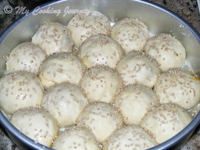 Brushing round balls in cake tin.