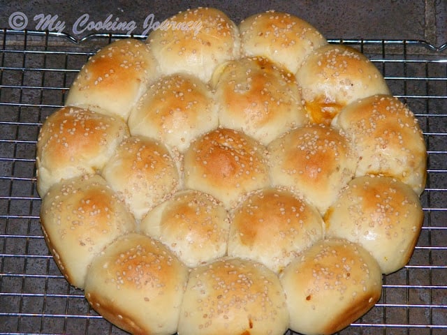 Baked buns on a wire rack for cooling.