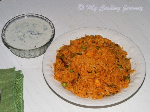 Tamatari Kasoori Pulao in a plate with raita