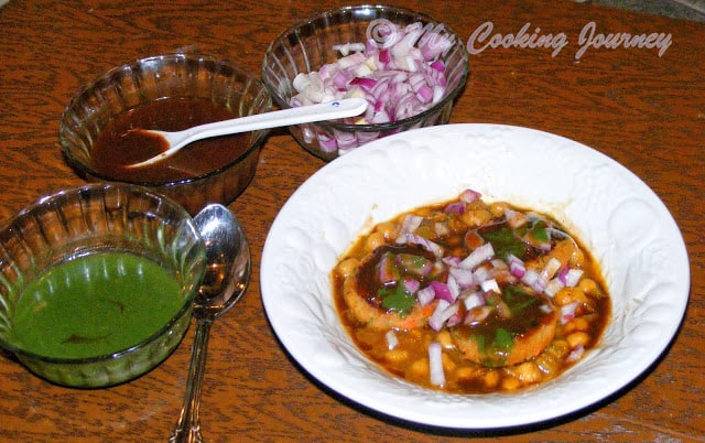 Aloo Tikki Chole Chaat  with green chutney and sauce.