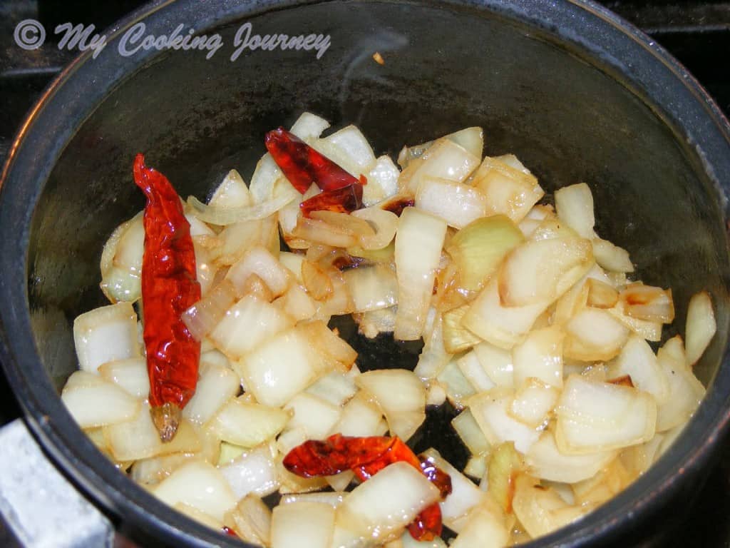 Chopped onions and red chilies in a pan.