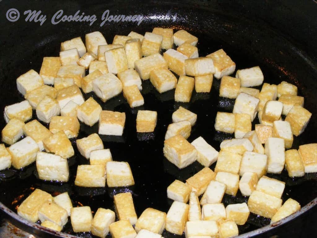 Cooking the cubed tofu in a pan with oil