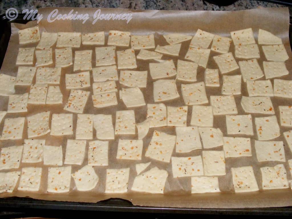 Transferring the cut pieces of Savory Herb Cookies dough