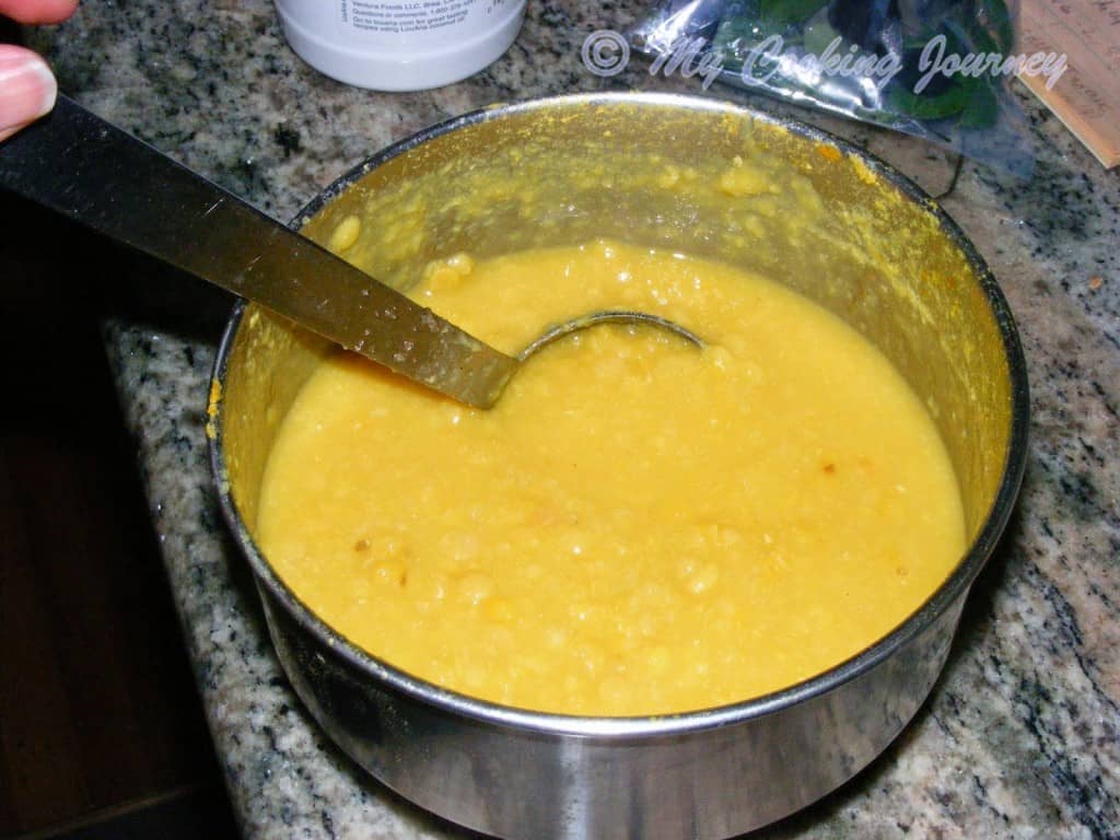 Mixing the cooked tuvaram paruppu with spoon