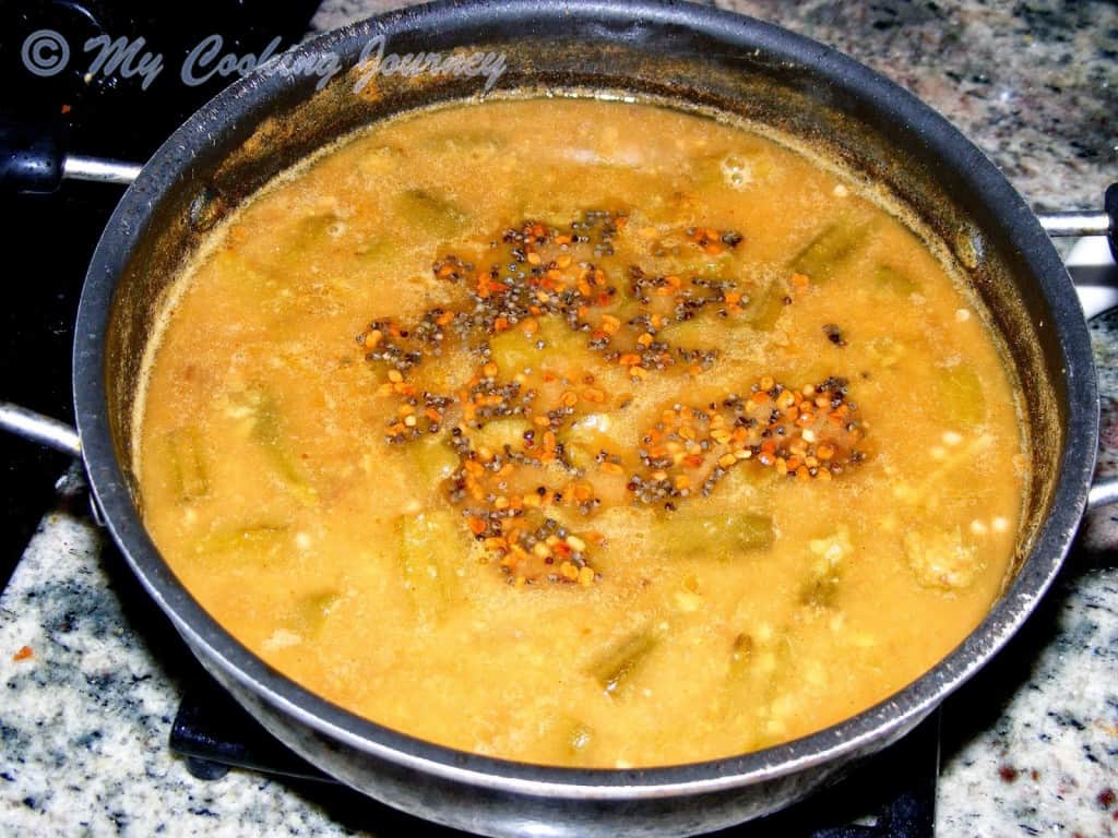 mixing seasoning into sambhar