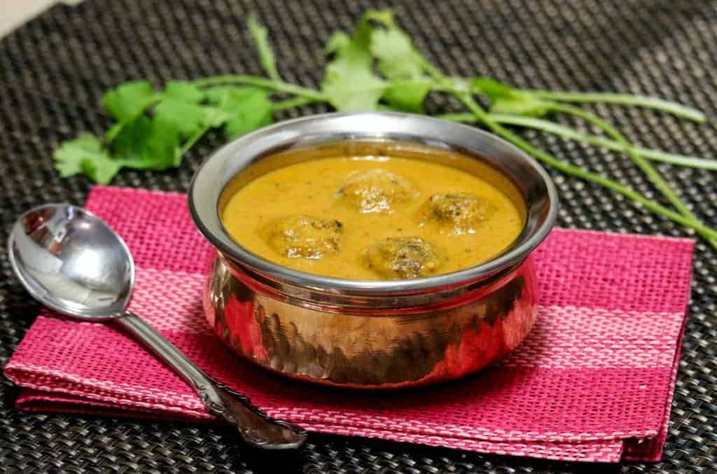 Cabbage and paneer kofta curry in a bowl with spoon