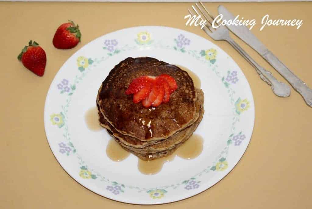 Oats and Wheat flour pancake is served with berries and maple syrup