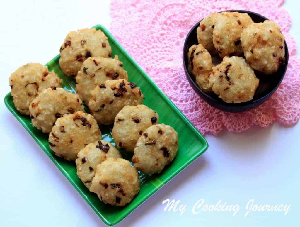 Poha Vadai in a green plate and some on the side in a black bowl