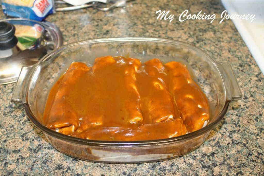 Enchiladas coverd with sauce in a baking tray
