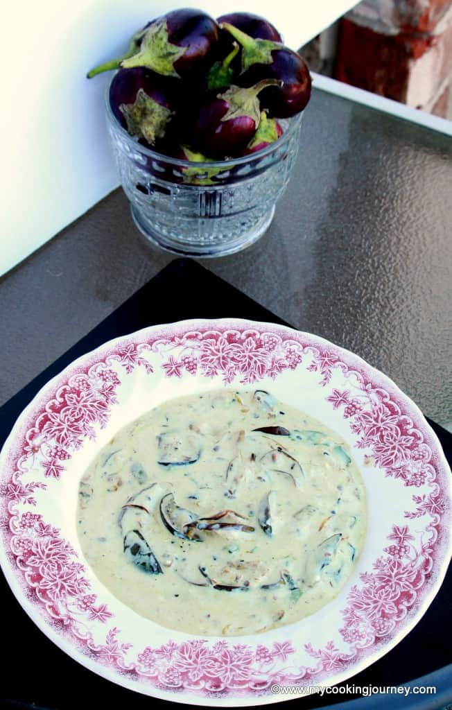 Dahi Baingana in a white bowl with egg plant in the background