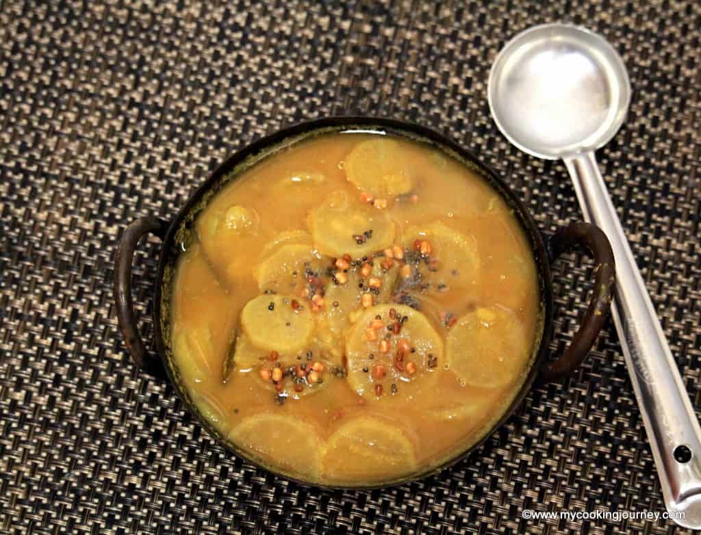 Mullangi Sambhar in Kadai with cooking spoon.