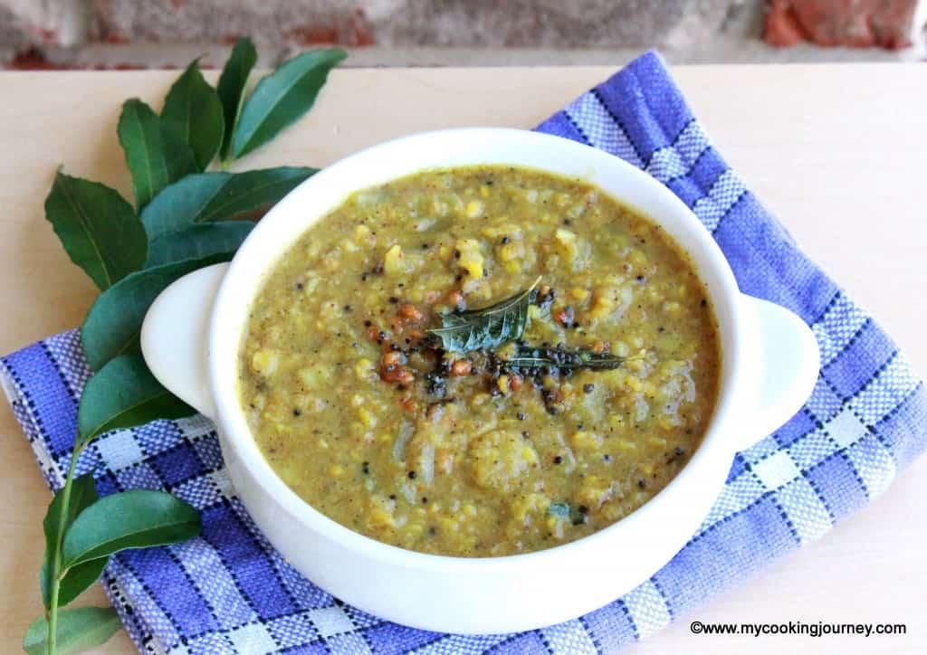 Ridge gourd kootu with a sprig of curry leaves in the background