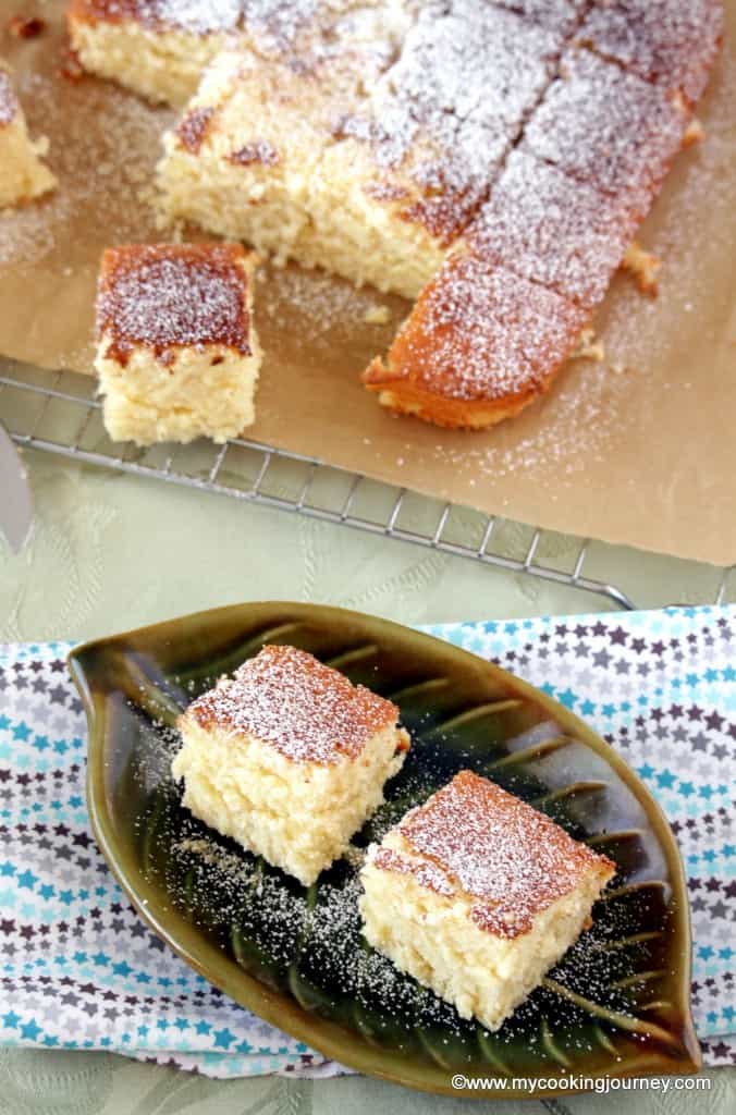 Hot Milk Cake on a green plat with the whole set in cooling rack