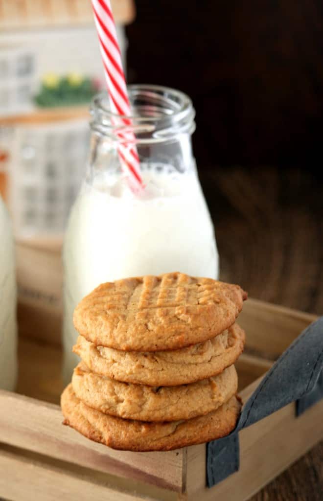 Peanut Butter Cookies stacked with milk in the background
