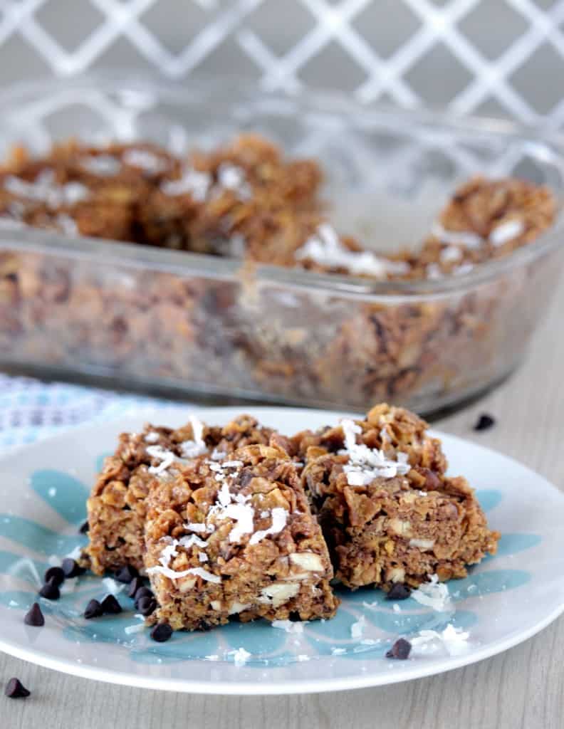 Peanut Butter chocolate Cereal Bar in a plate in foreground with rest in the baking tray in the background.