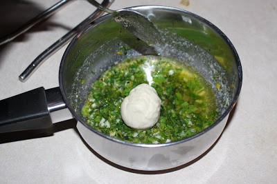 dipping dough balls in herb and butter mixture