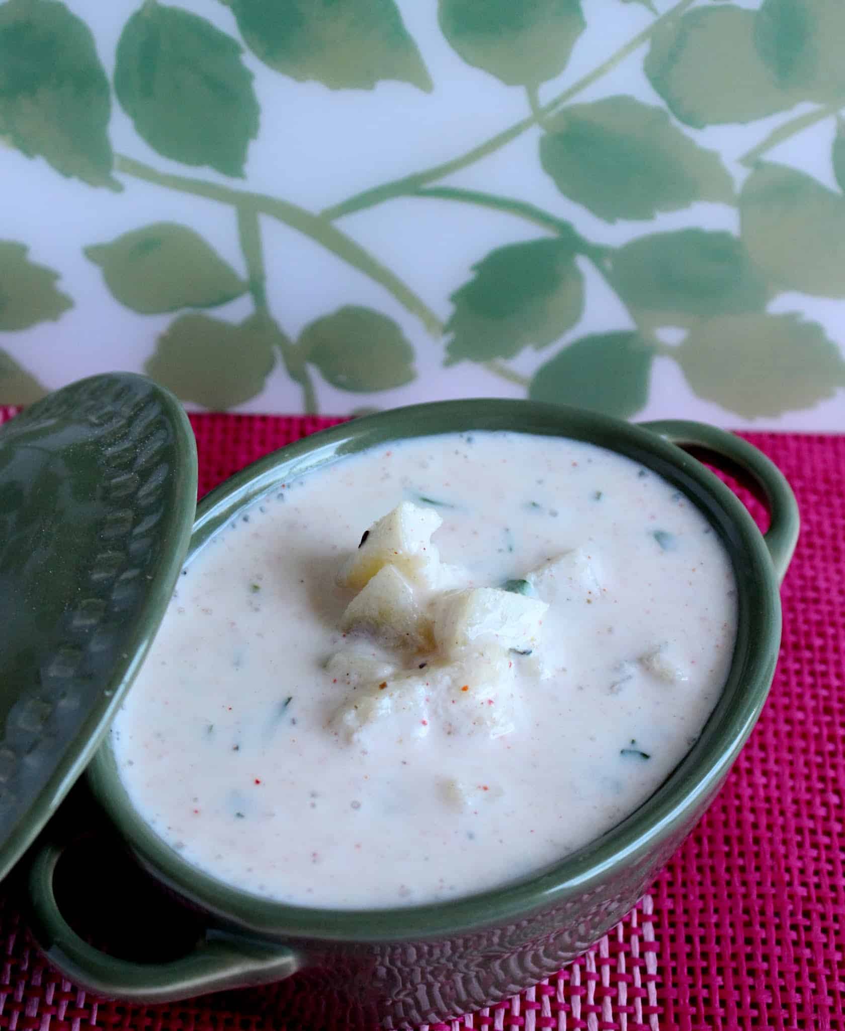 Potatoes and yogurt in a green bowl with lid