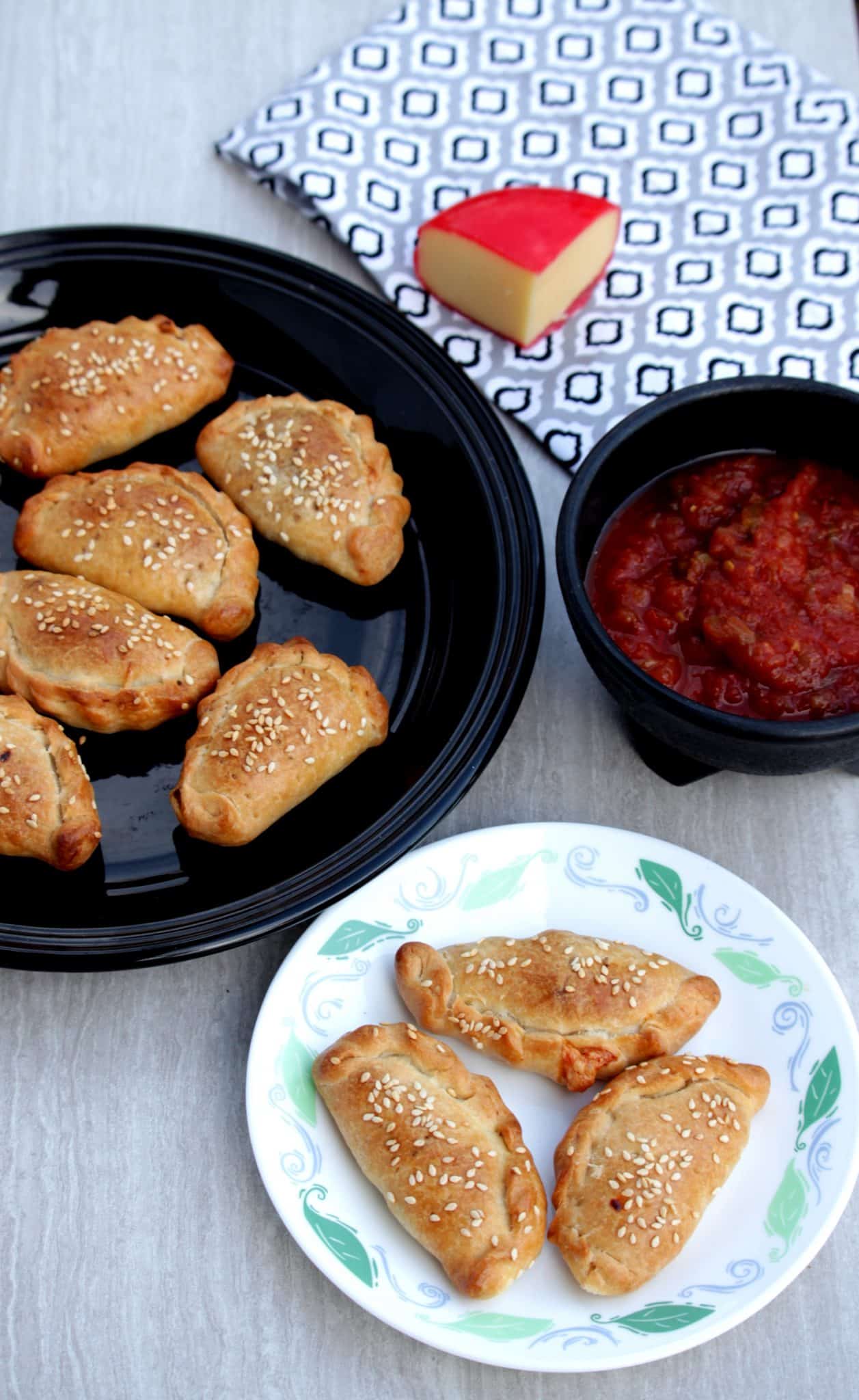 Onion and cheese empanadas in a plates with salsa on the side