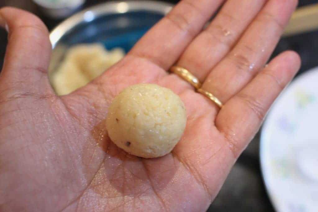 Rolled coconut ladoo in palm