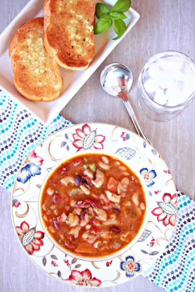 Vegetarian15 Bean Soup in white floral  bowl with bread on the side