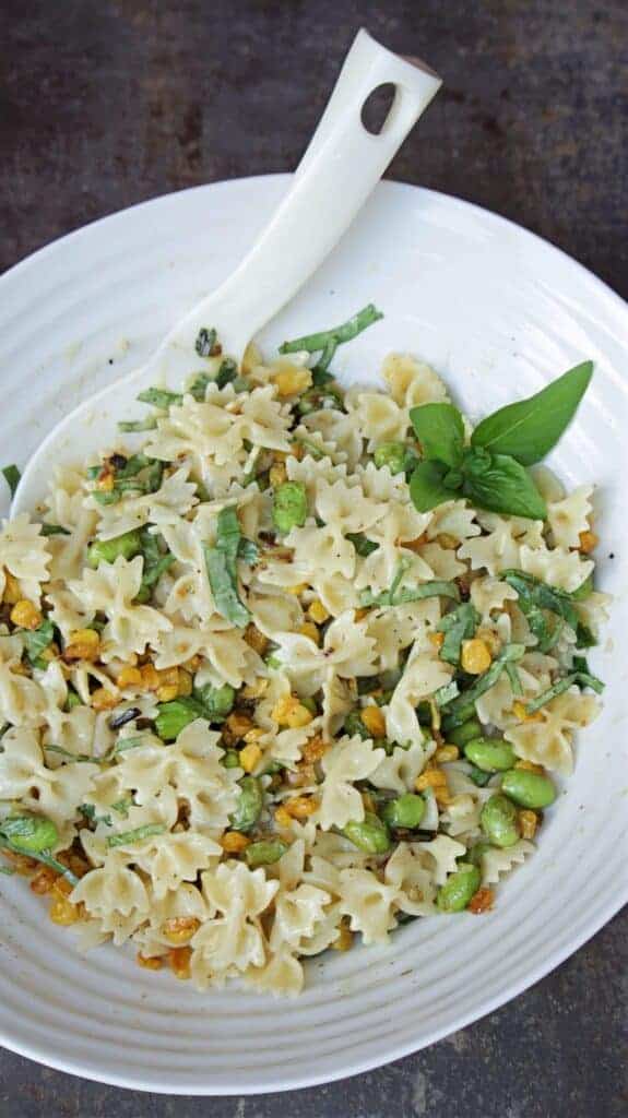 Vegetarian Pasta Salad with roasted corn and edamame in a white bowl