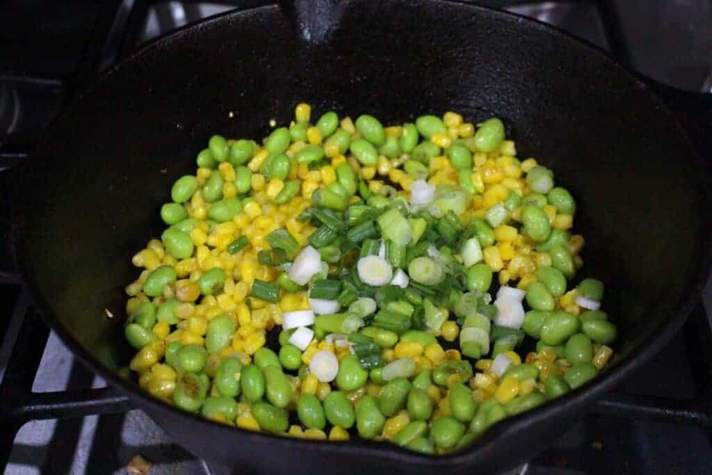 Roasting corn, edamame and spring onion in cast iron