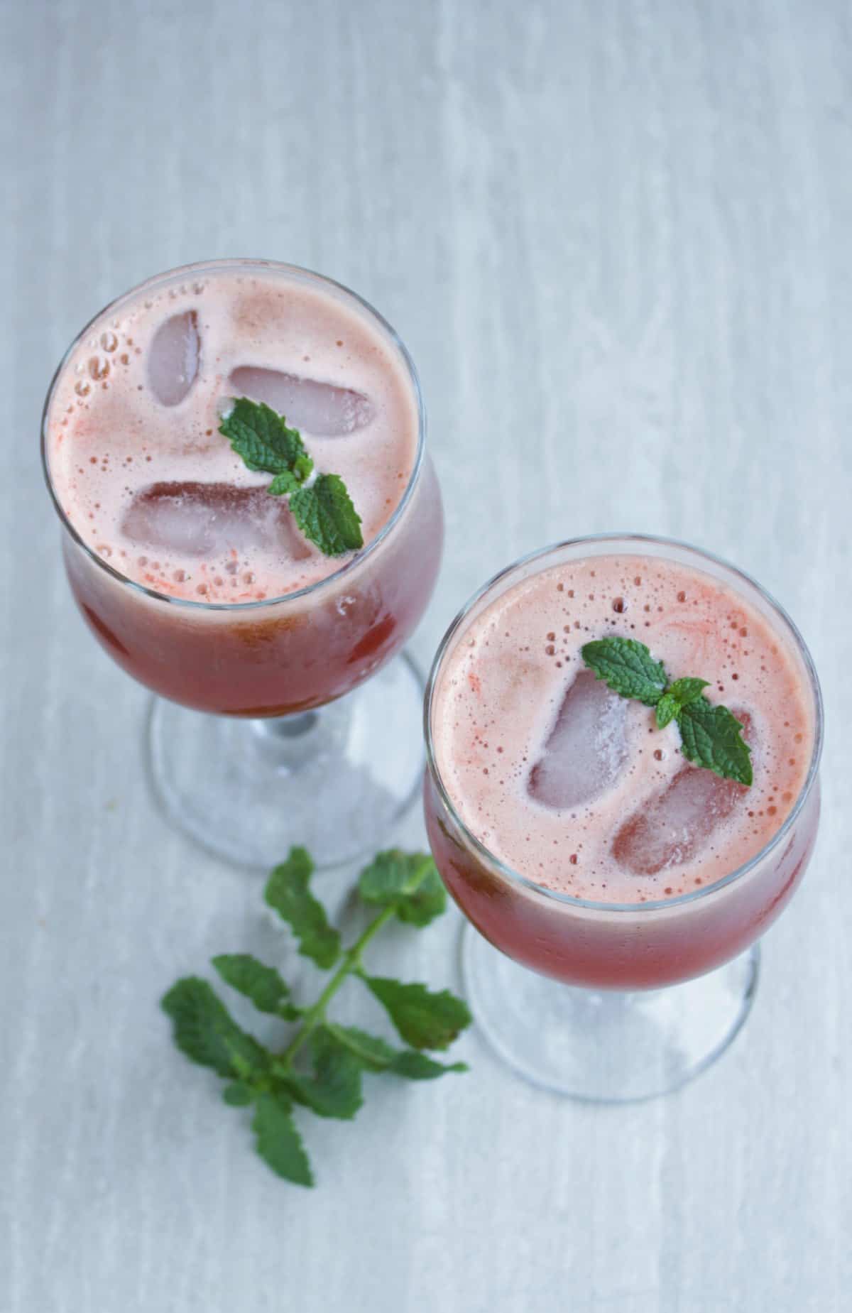 Watermelon juice in two glasses with mint on top and side