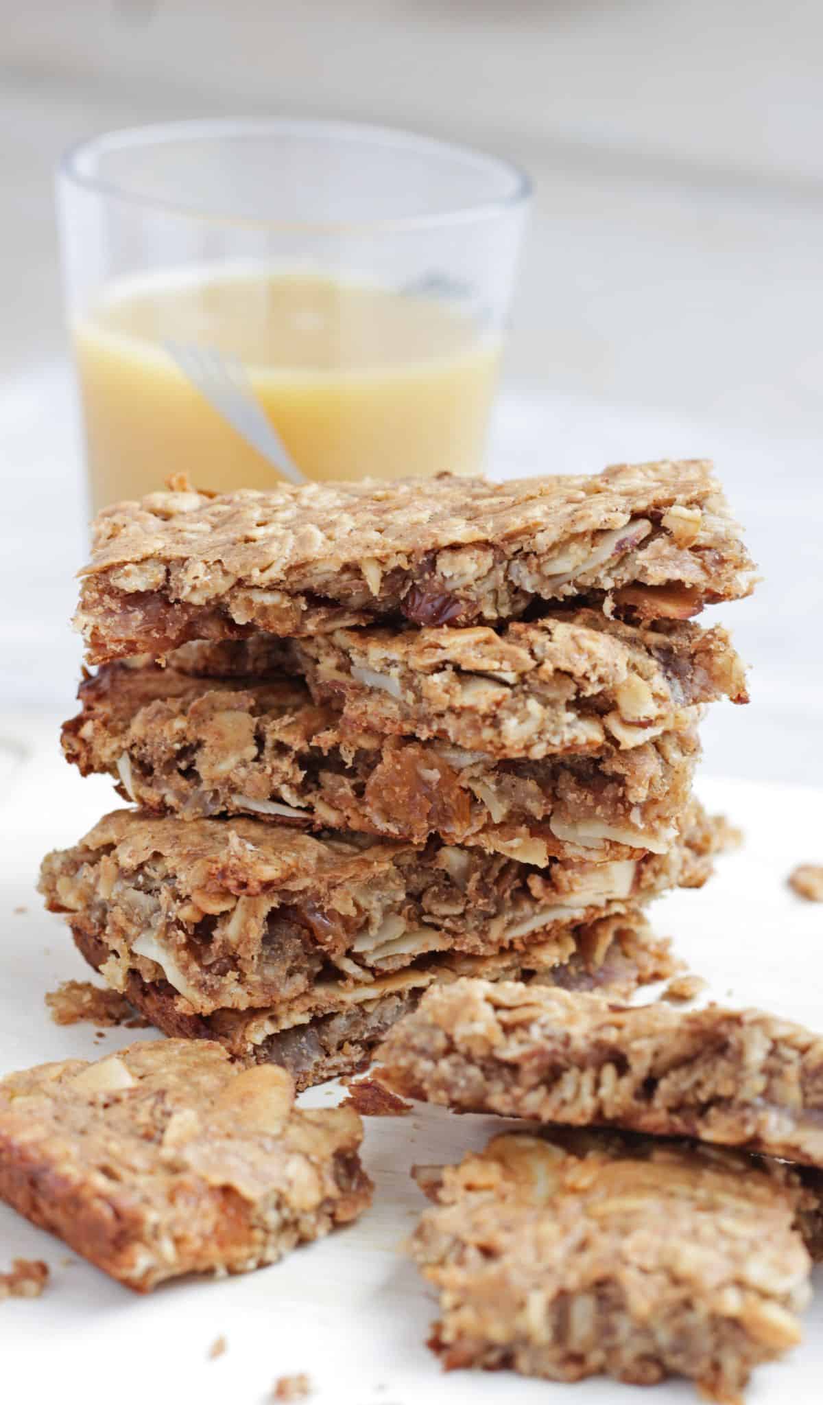 Banana oatmeal bar stacked with orange juice in the background