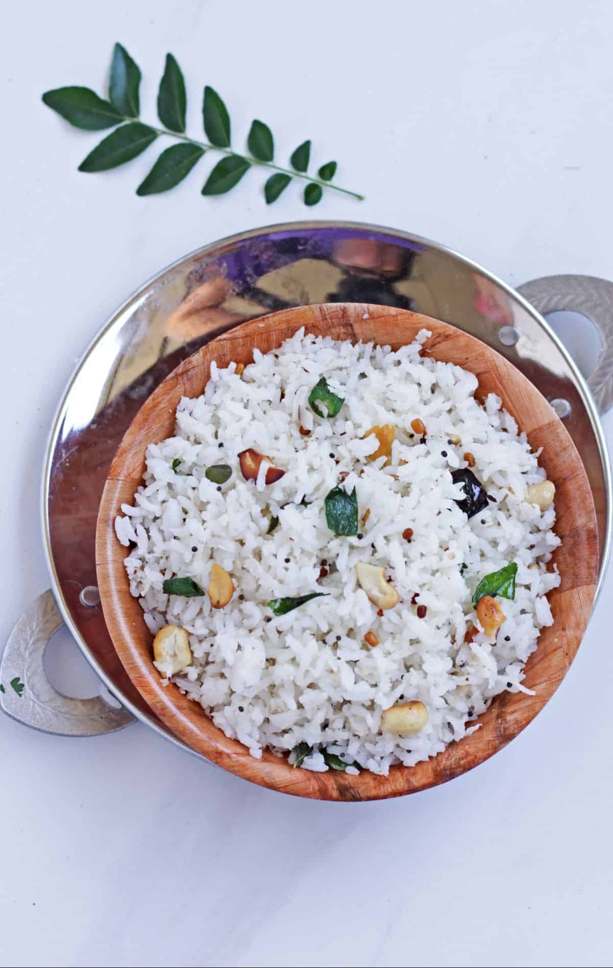 Coconut rice in a bowl with curry leaf in the back ground