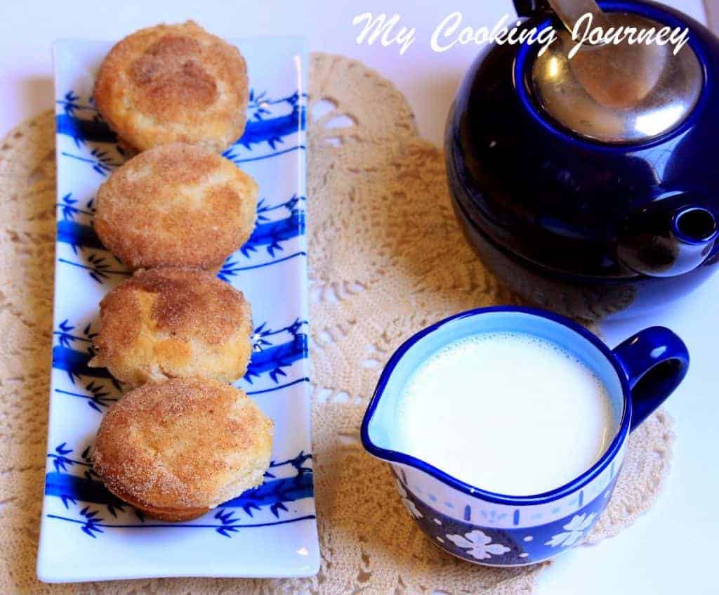 Cinnamon Sugar Muffins are in a rectangle tray with a cup of milk