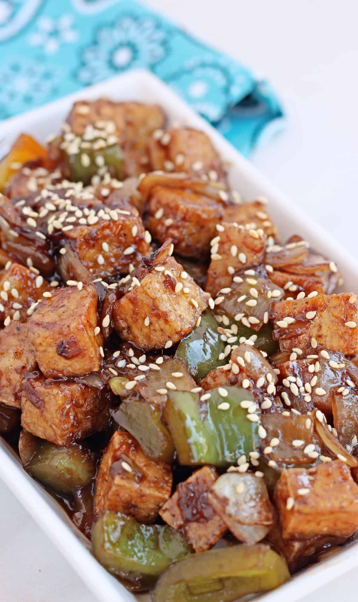 Air fryer tofu stir fry in a plate garnished with sesame seeds.