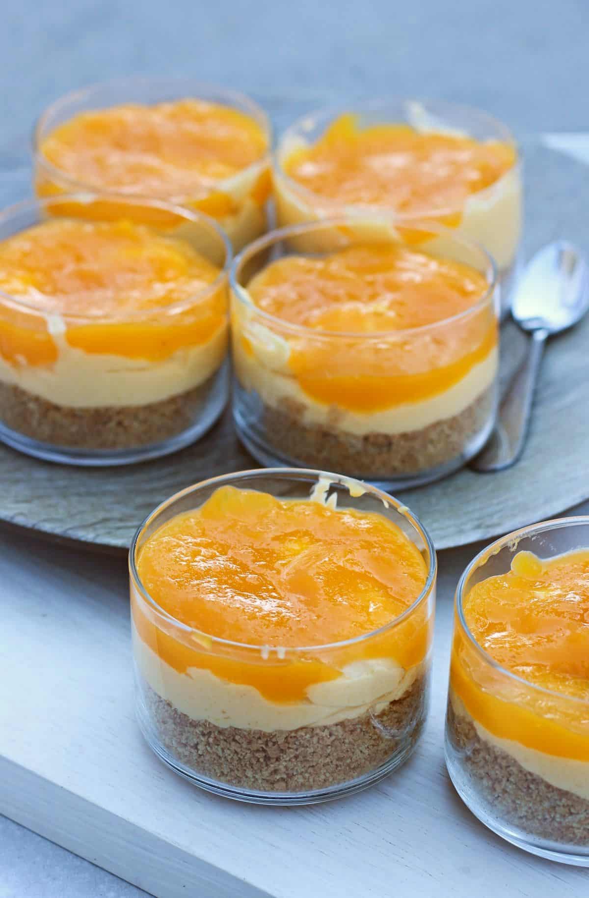 layered mango cheesecake in individual cups
