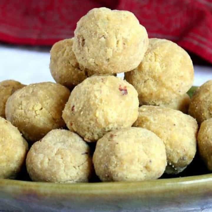 Besan ladoo stacked on a green plate - Feature Image