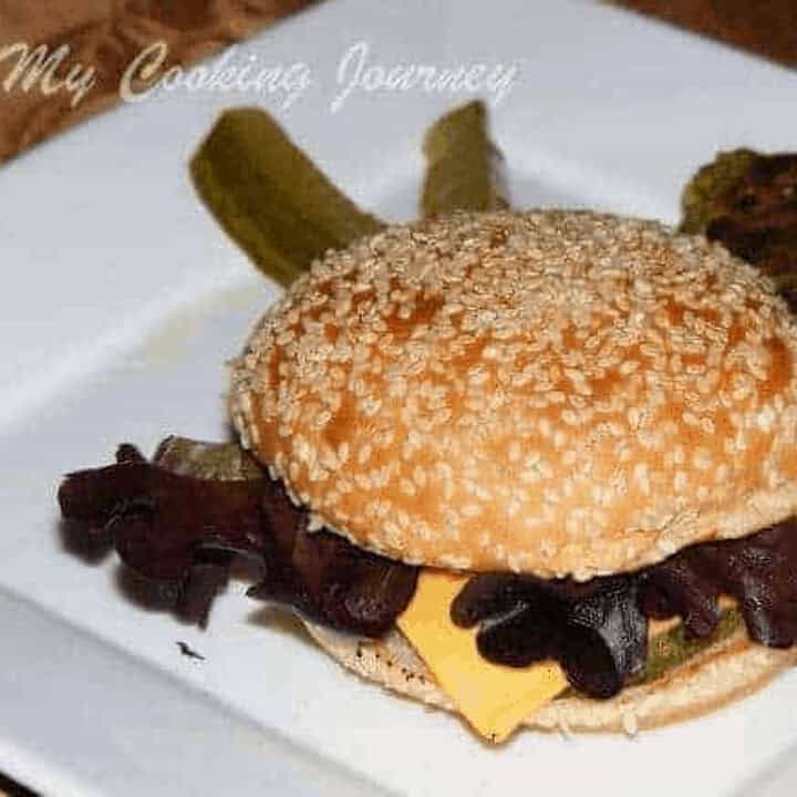 White Bean and Greens Burger in a White Plate with pickles - Feature Image